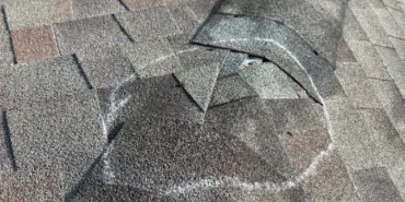 Storm damage chalk-marked on a shingle roof during a Titan Roofing inspection